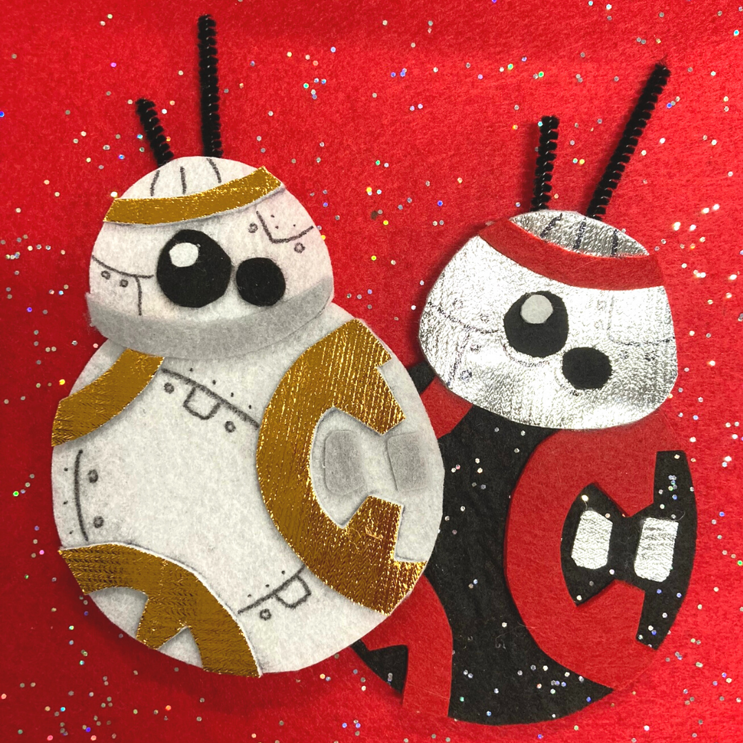 Two droids from Star Wars made out of felt. One is orange and white. the other is red, black, and silver.