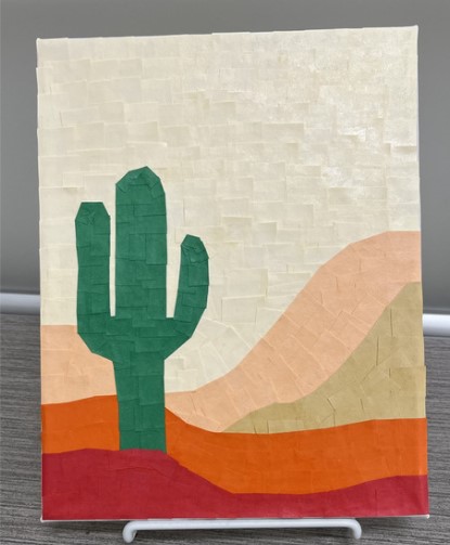 Picture of a cactus with different colored sand behind it, all made out of pieces of paper overlapped
