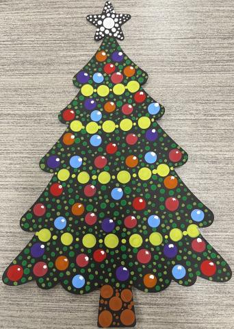 Picture of a paper tree with colorful dots on top of a black background.